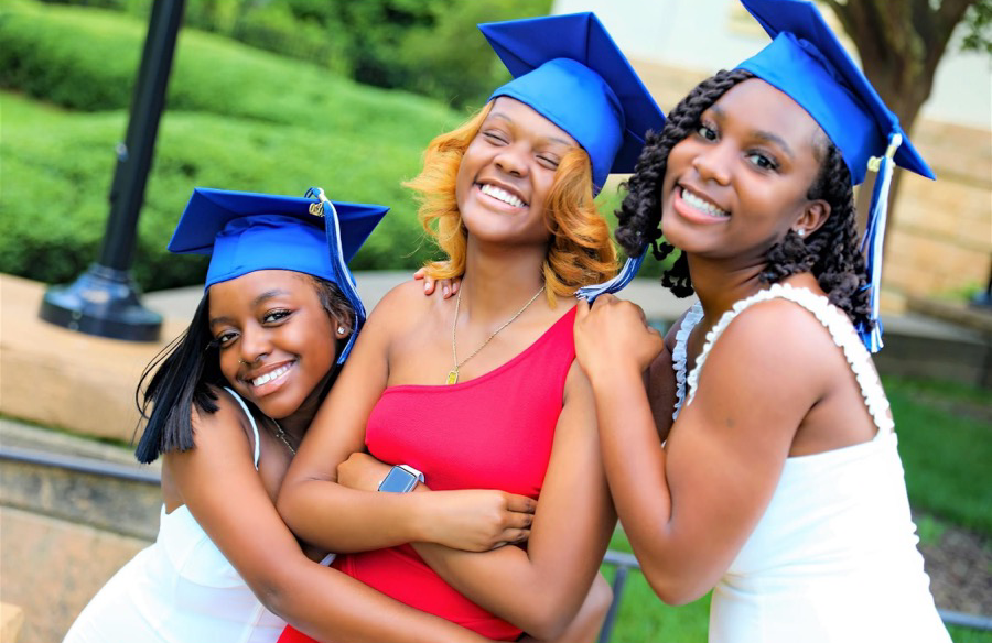 Three girls wearing graduation hats