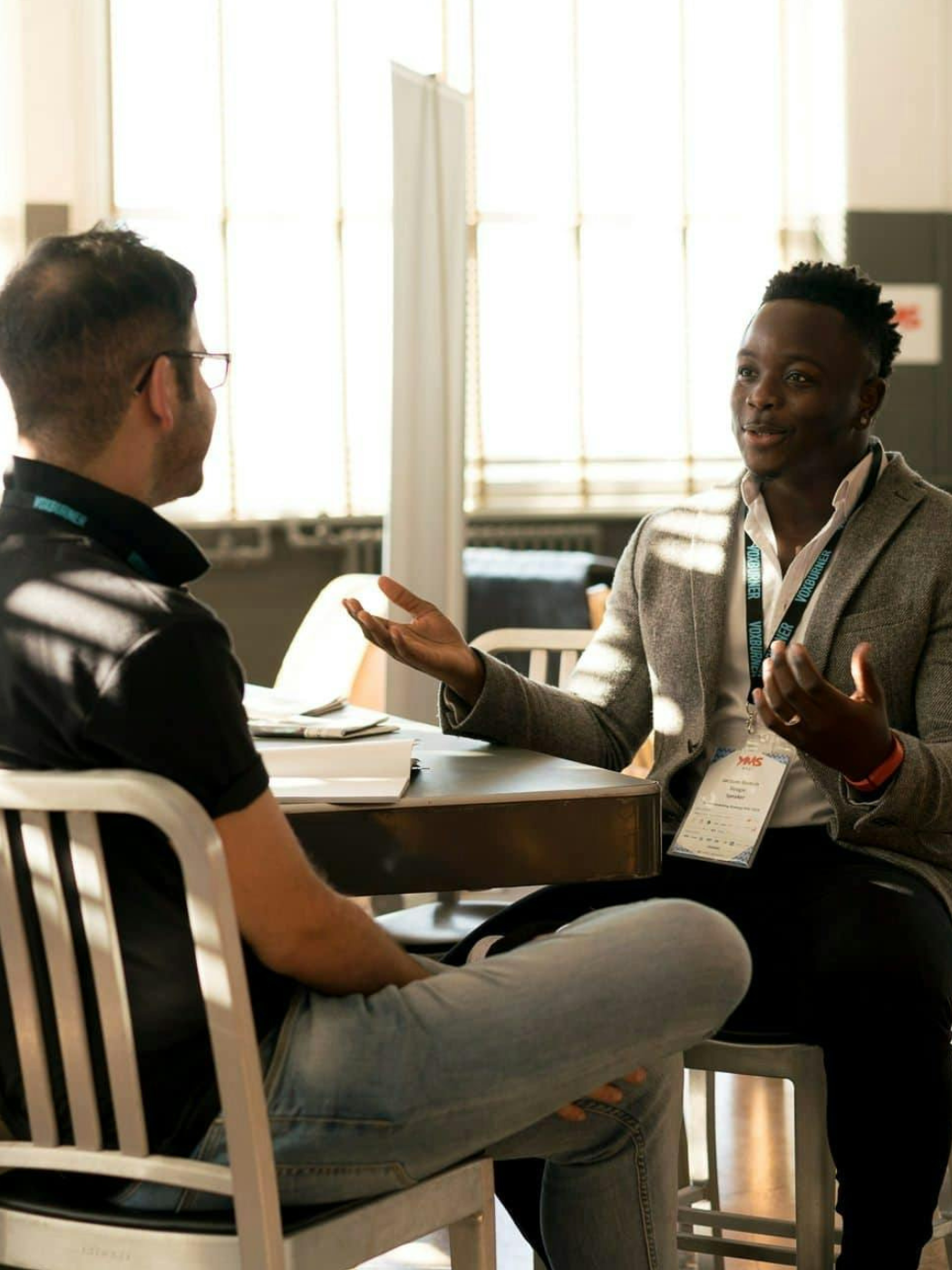 Two male teachers talk through instructional practice in a coaching session