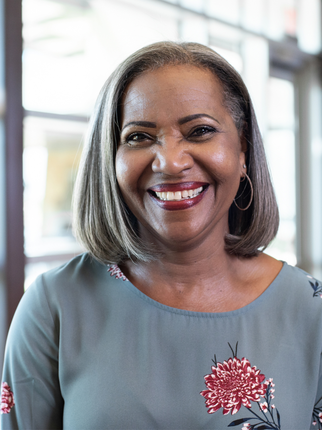 Smiling Black principal in hallway of school building