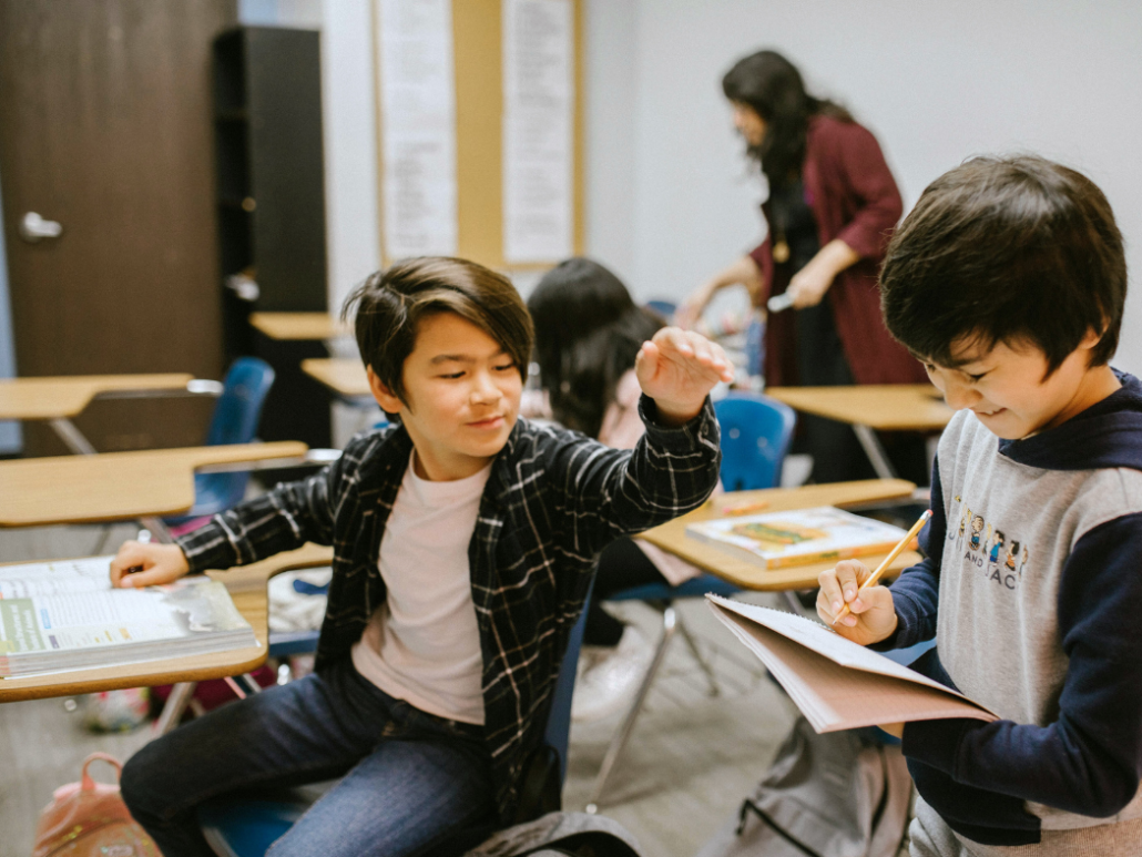 Two middle school kids engaged in the classroom having fun