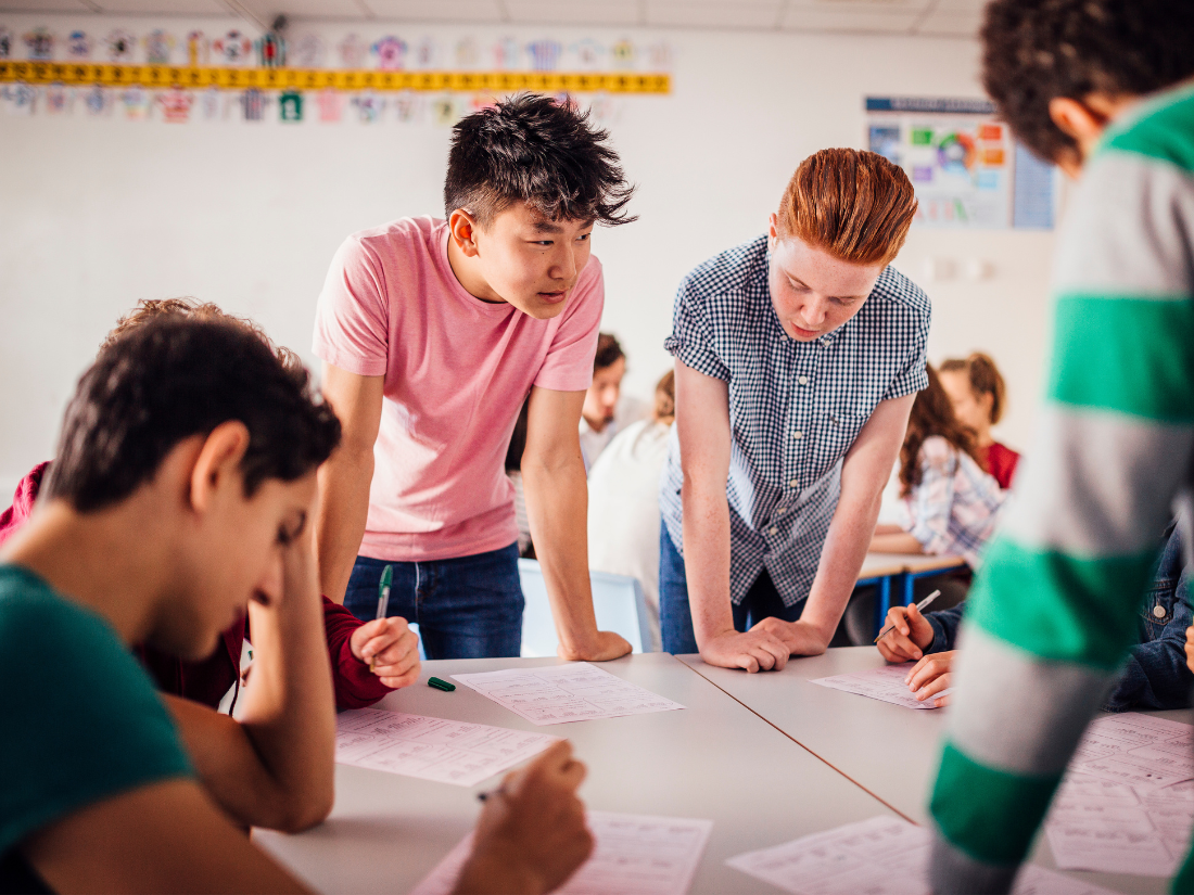 Students engaged in work together around the table