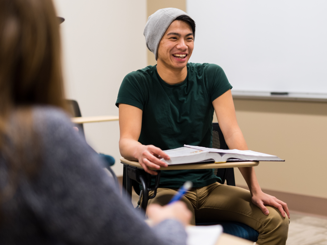 High school male student engaged in classroom conversation and learning