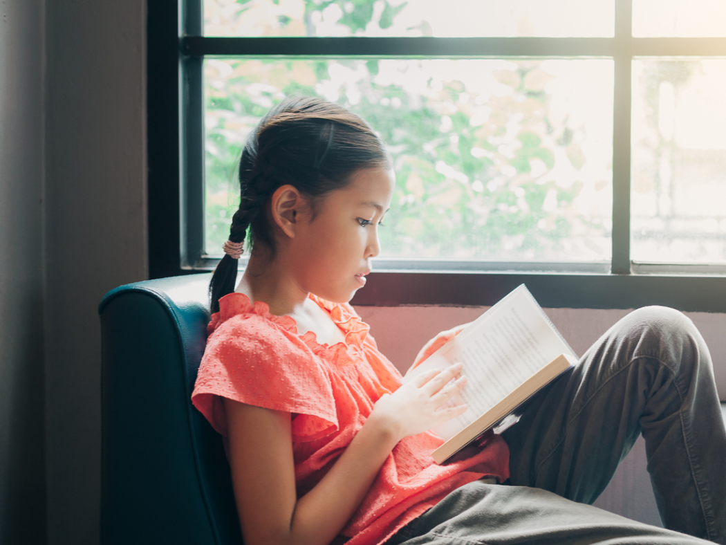 Young middle school student reading in the library