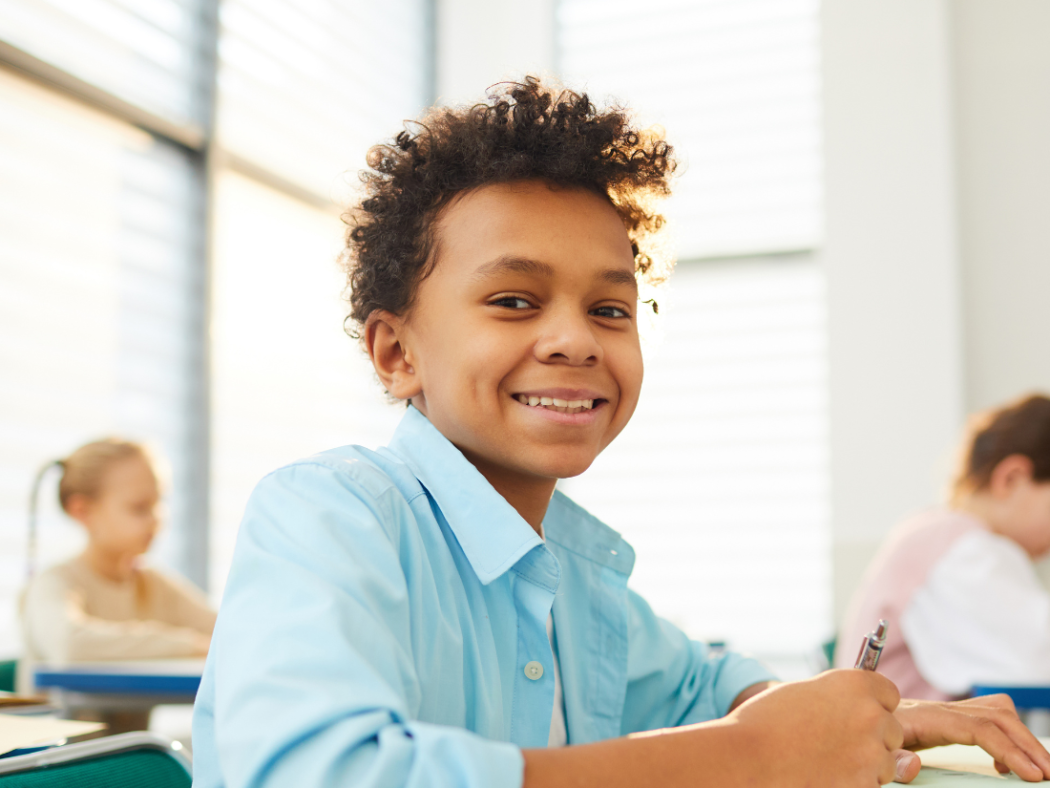 Young student at desk in classroom excited to work on math