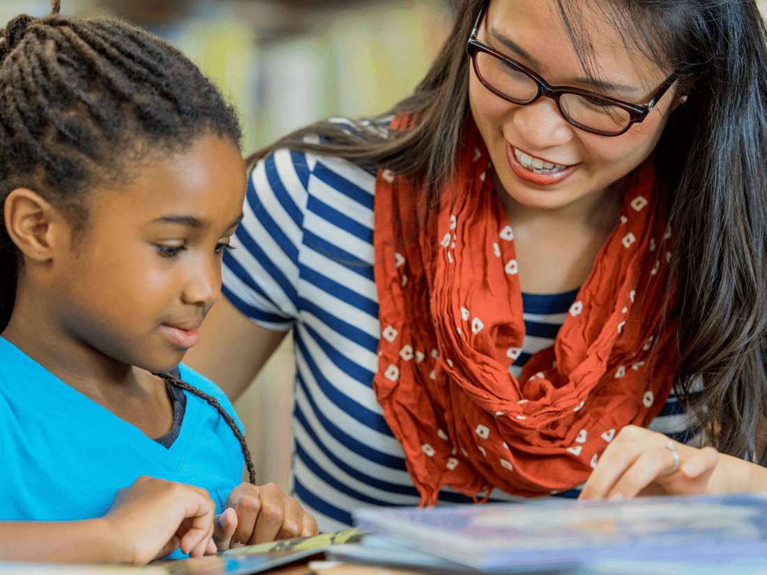 Teacher working with elementary school student on the science of reading