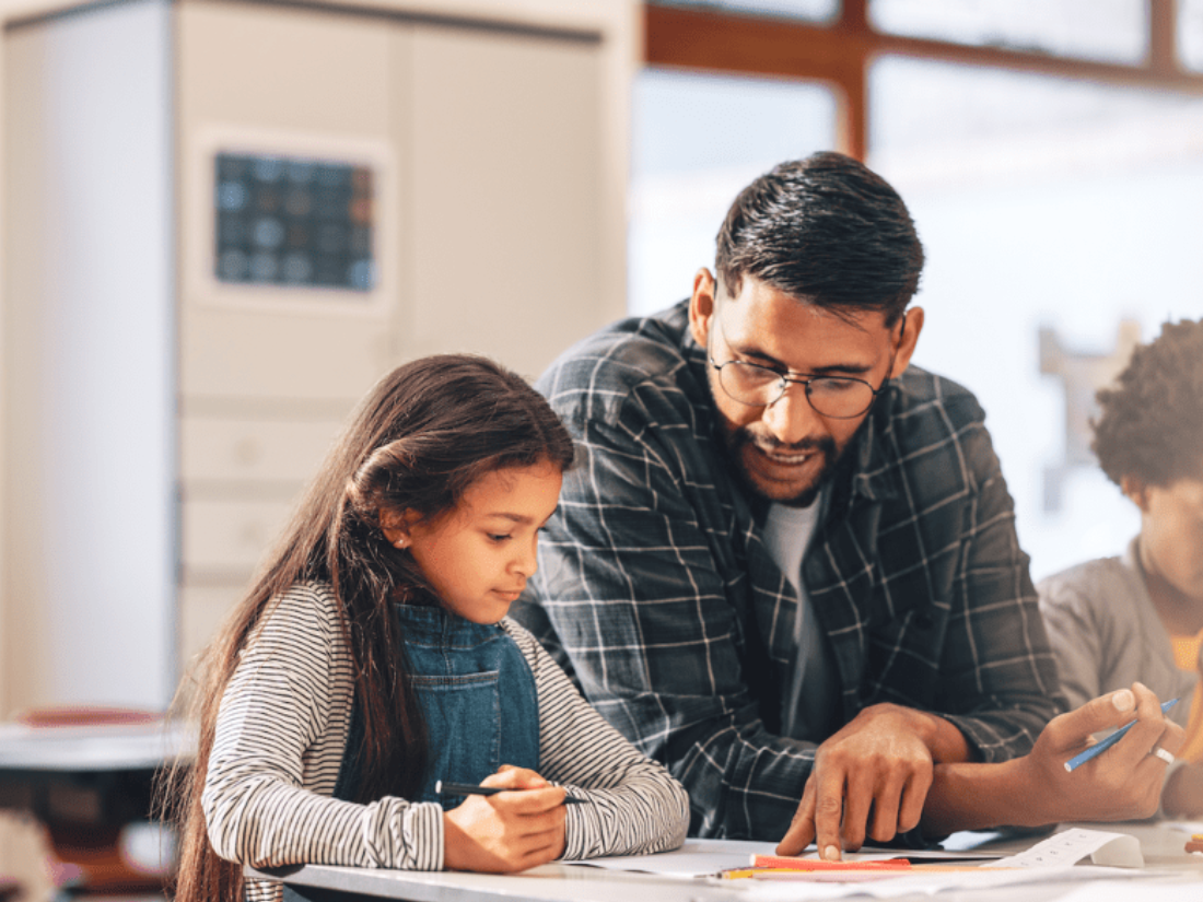 Teacher working with student at table