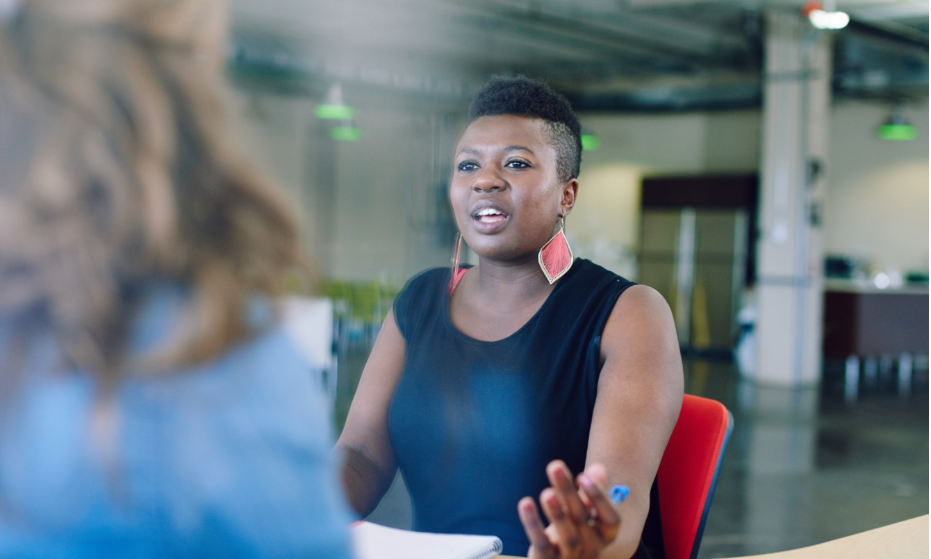 Black female teacher engaged in coaching conversation at school