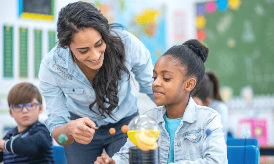 Young teacher working a young Black student on a science project