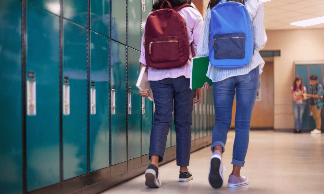 Two kids walking through the school hallway to class